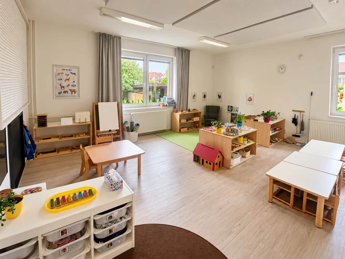 Montessori třída s nízkými poličkami s pomůckami.