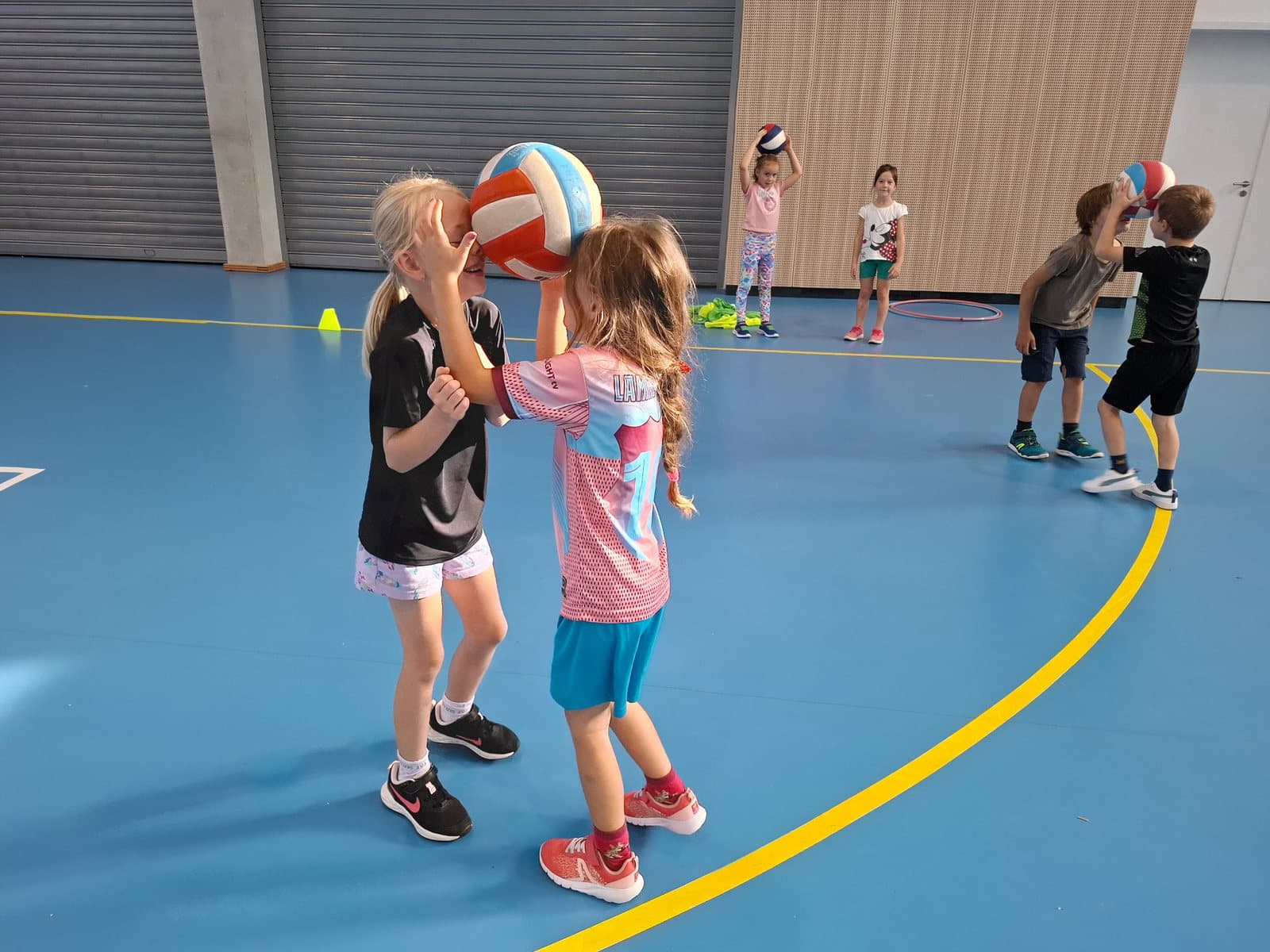 Děti si ve dvojicích předávají basketbalový míč během Týdne basketbalu na ZŠ Sofie.